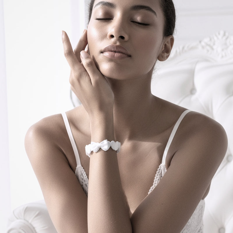 Sweetheart White Heart Bow Bracelet on model with glowing skin