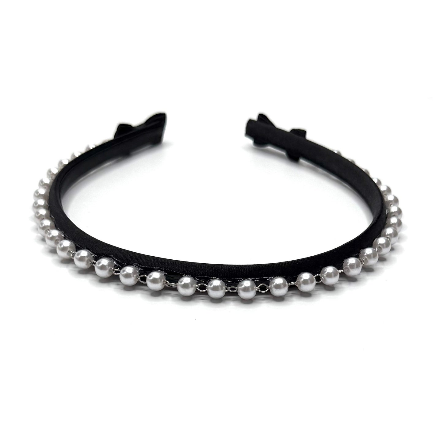 Black headband with pearl beads on a white background with black bows