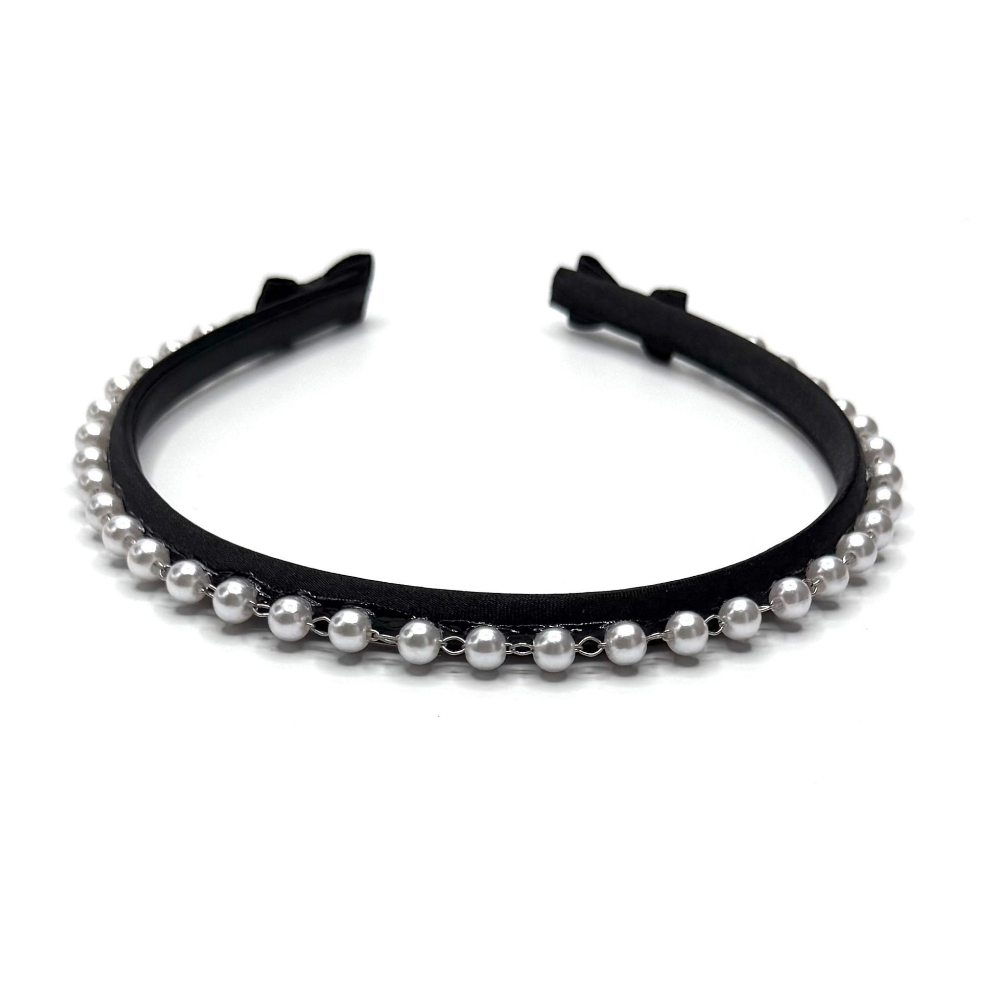 Black headband with pearl beads on a white background with black bows