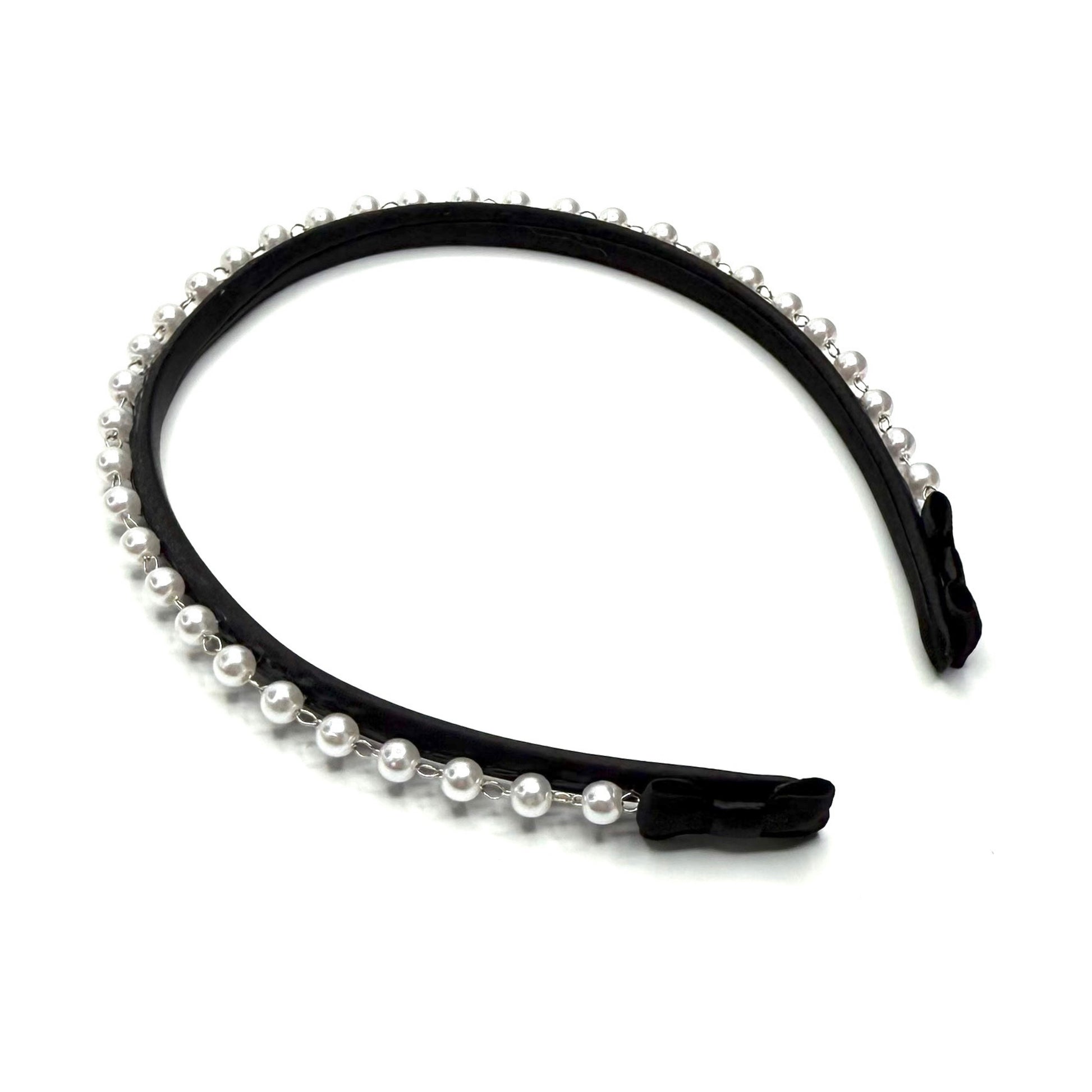 Black headband with pearl accents on a white background