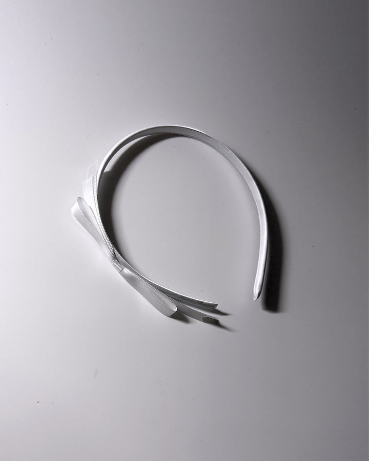 Enchantress White Bow Headband on white background with pretty light