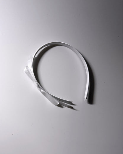 Enchantress White Bow Headband on white background with pretty light