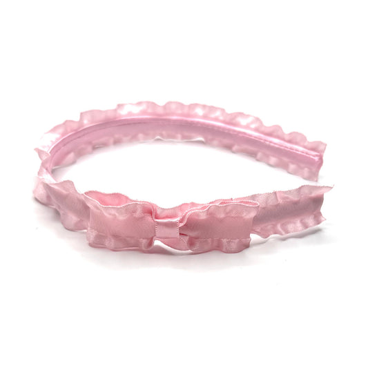 Pink headband with ruffled design on a white background