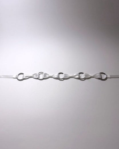 White Bow Headband with Silver O Rings laid flat on softly lit surface