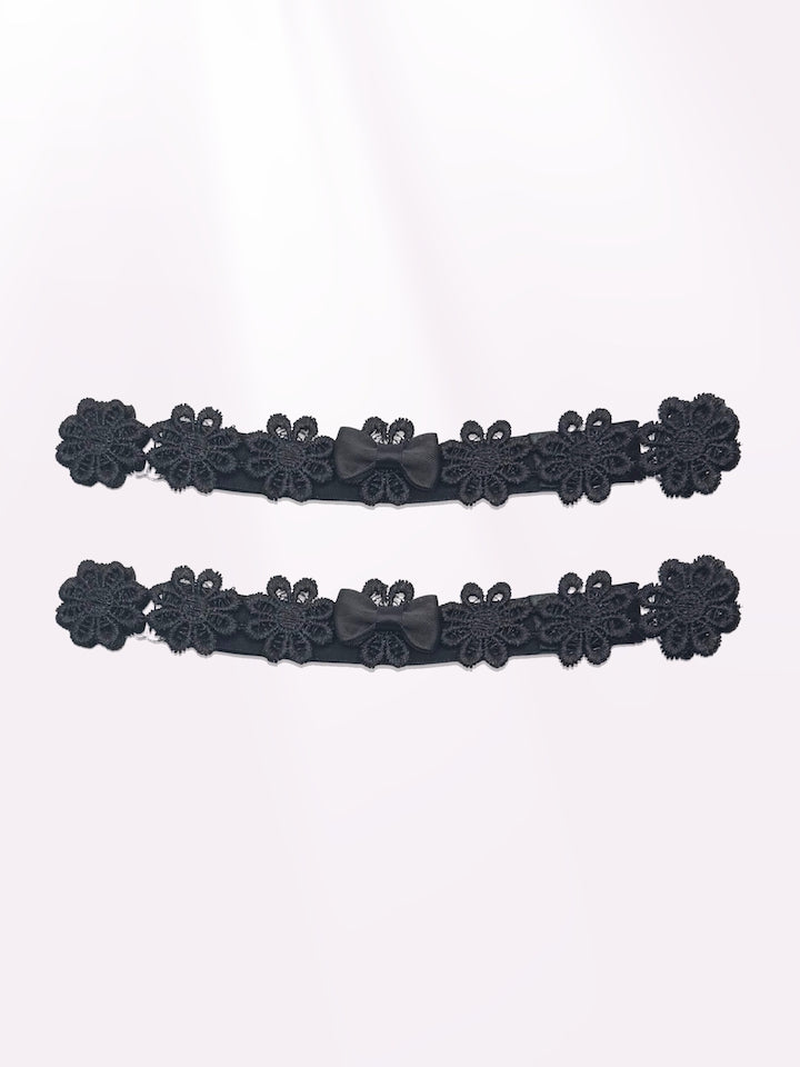 black flower bow leg garters on light pink background