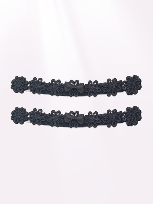 black flower bow leg garters on light pink background