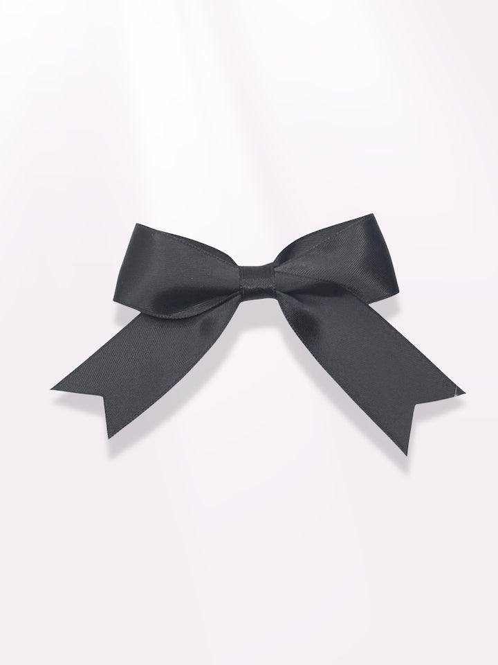 Black Bow Barrette on Light Pink Background