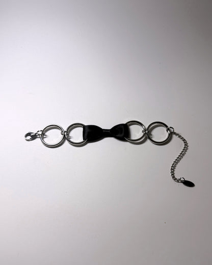 Black Bow Bracelet with Stainless Steel Loops on a softly lit background