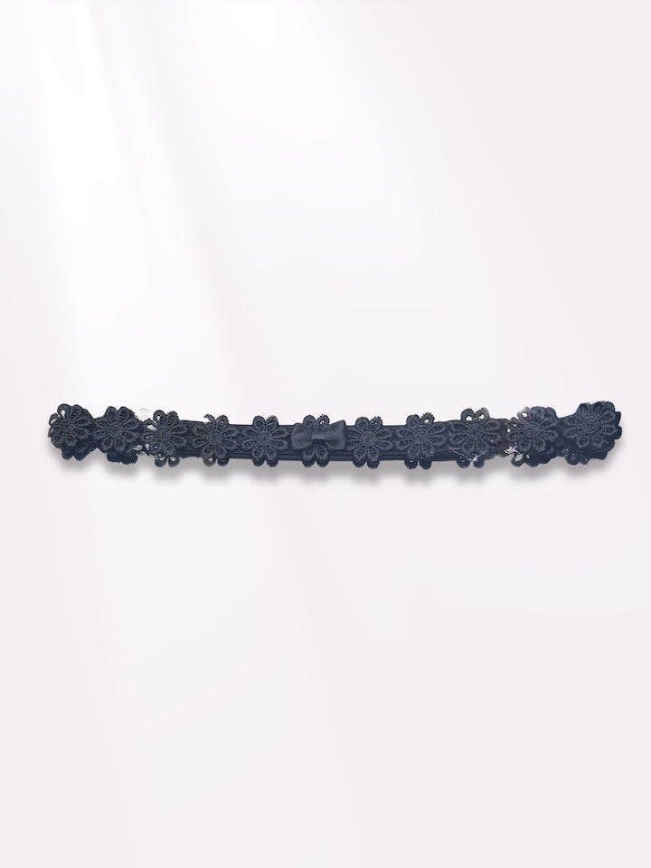 black flower bow belt on light pink background