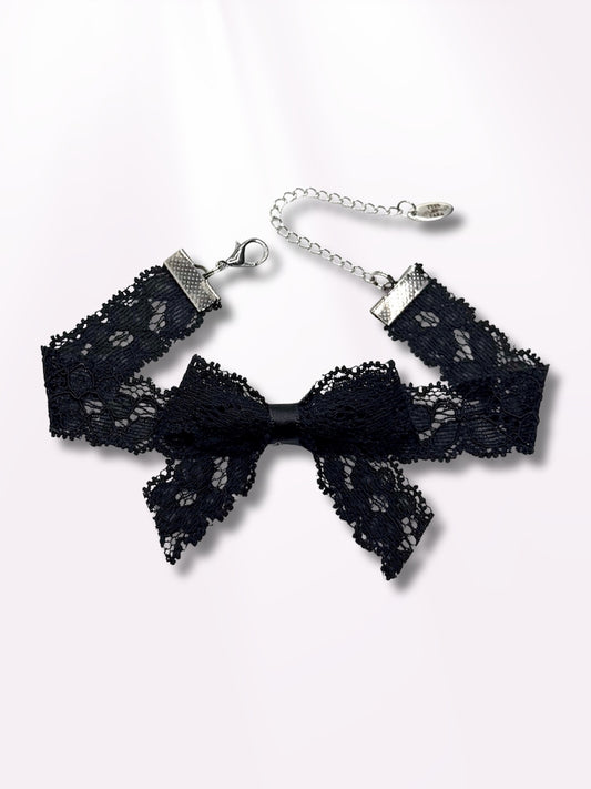 black lace bow anklet on light pink background