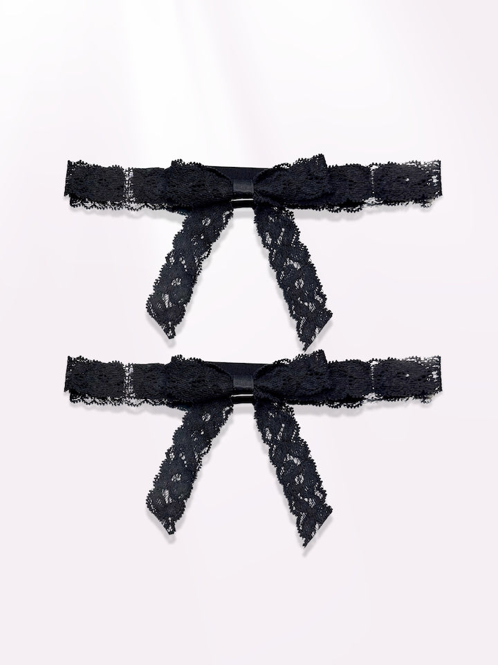 Bougee Black Lace Bow Leg Garters on Light Pink Background