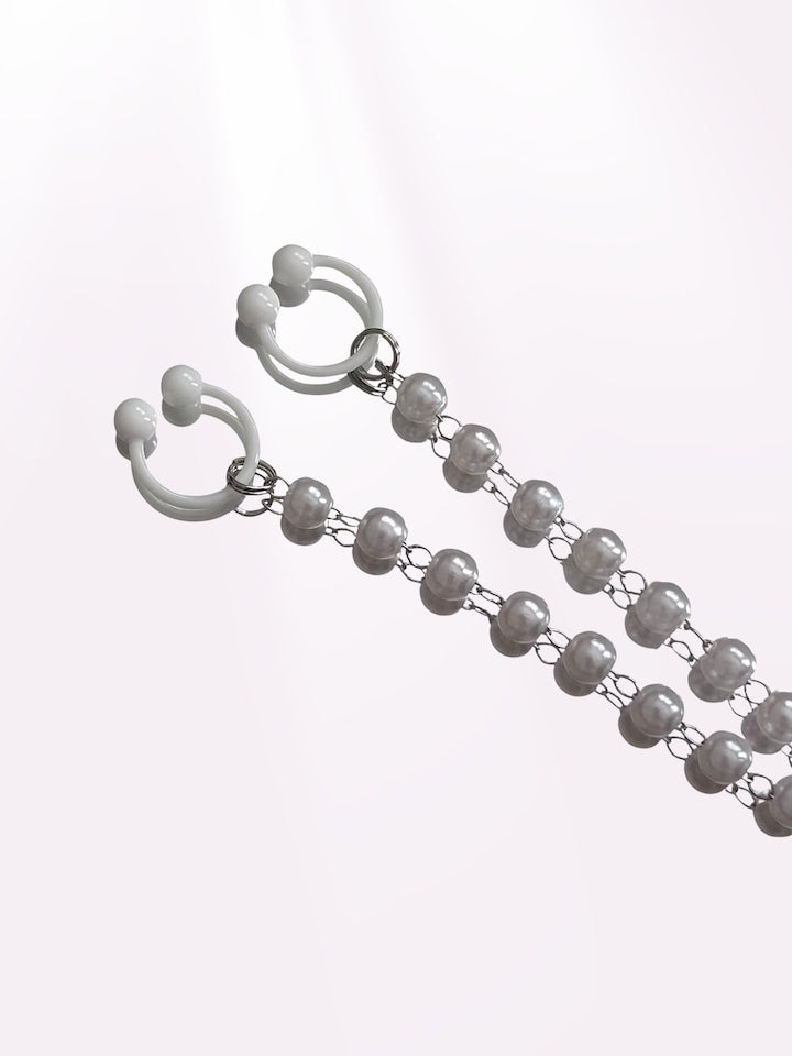 Pearl necklace clamps close up view on a pink white background