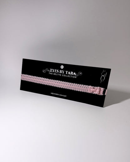 Pink elastic bow belt on black card