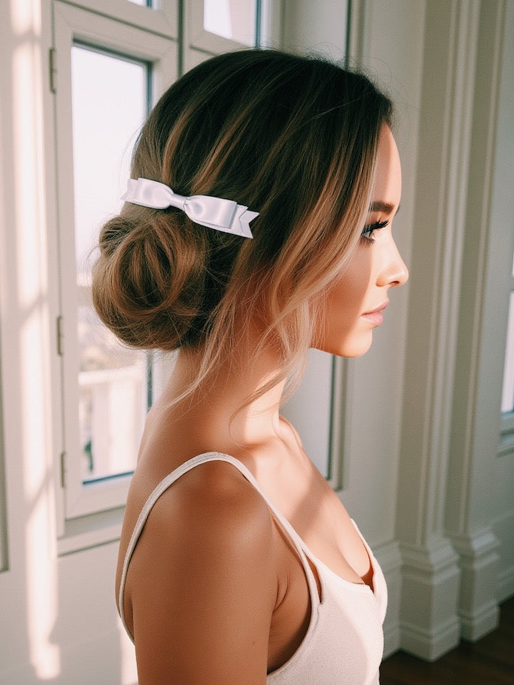 brunette model in elegant white enchantress hair bow barrette standing by a window