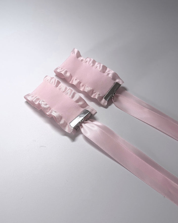 Maiden Pink Ruffled Handcuffs on softly lit surface