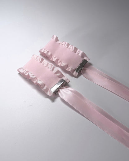 Maiden Pink Ruffled Handcuffs on softly lit surface