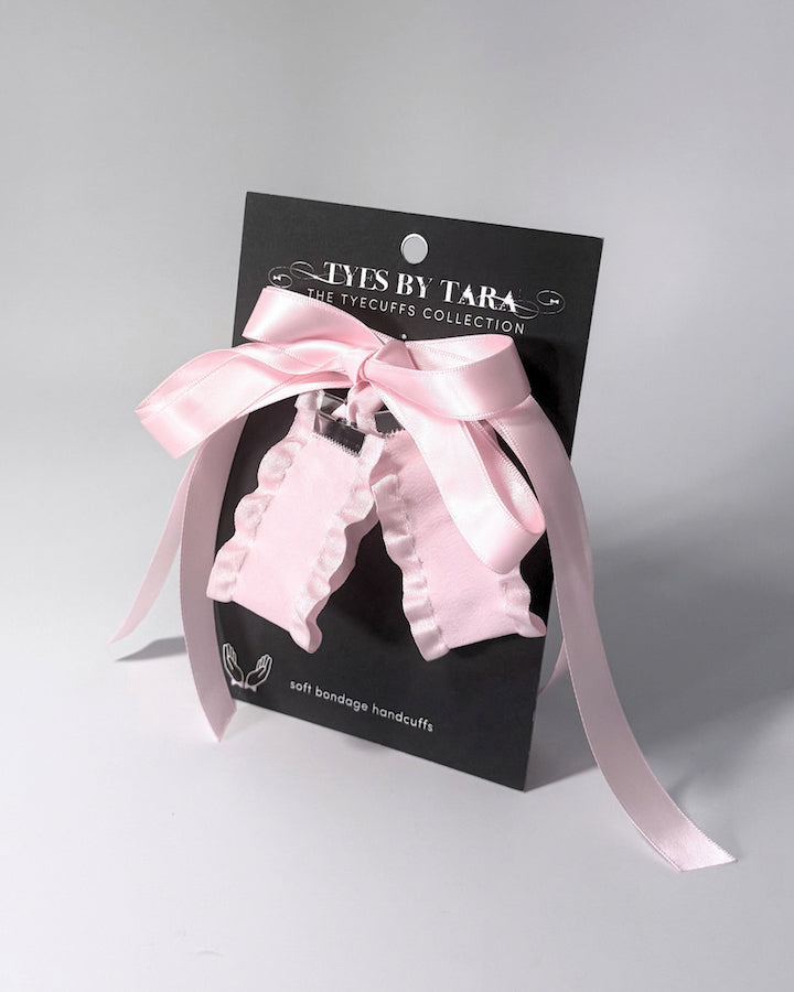 Maiden Pink Ruffled Handcuffs on softly lit surface on black card