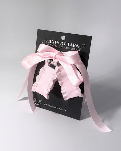 Maiden Pink Ruffled Handcuffs on softly lit surface on black card