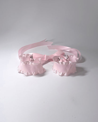 Maiden Pink Ruffled Handcuffs on softly lit surface