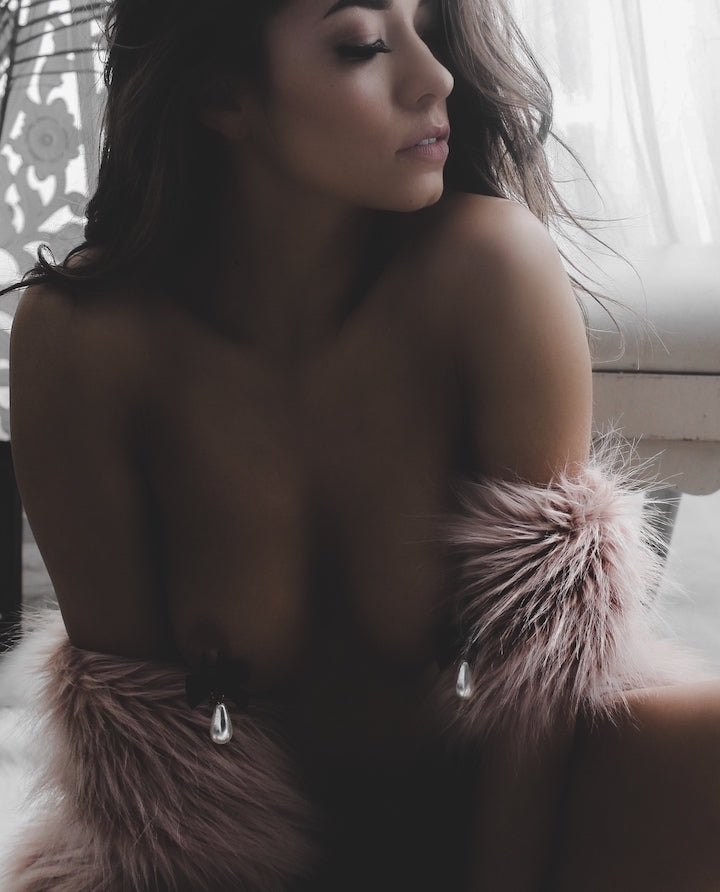 marie antoinette pearl nipple clamps on model in white boudoir with pink faux fur coat