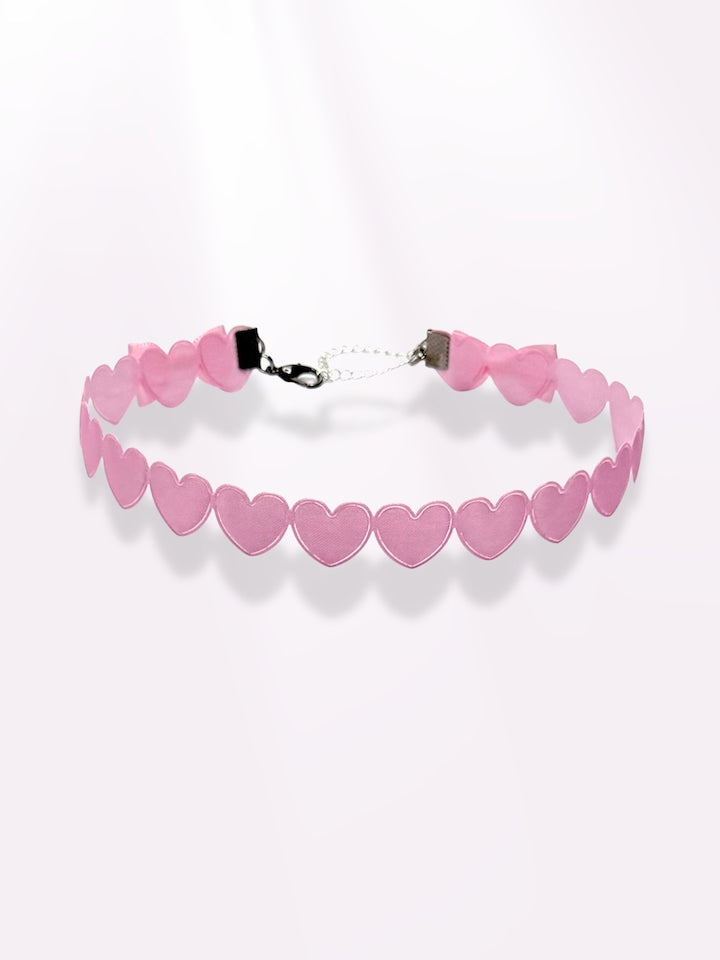 pink heart bow choker on light pink background