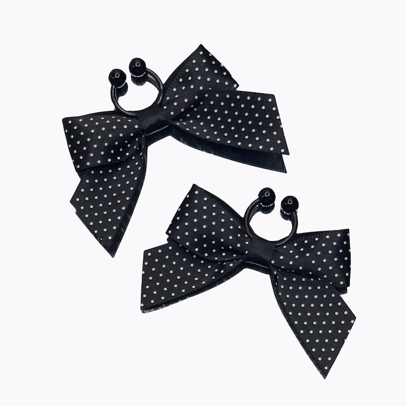 black bow pinup nipple clamps nipple jewelry on light pink background