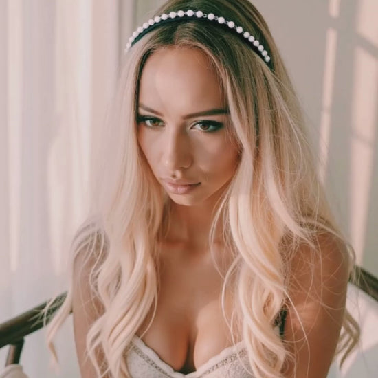 Model in Pearl Headband playing with her hair in elegant white boudoir