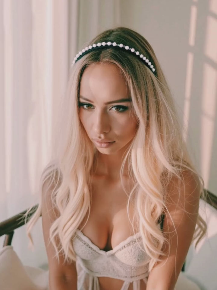 Model in Pearl Headband playing with her hair in elegant white boudoir