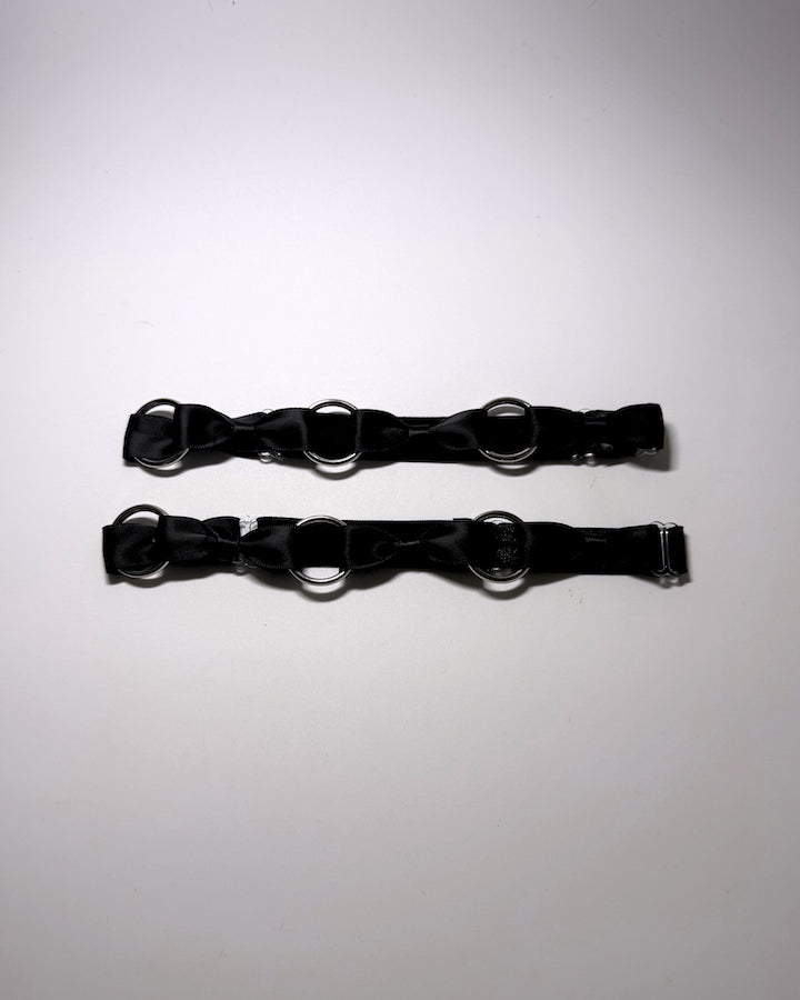 runaway black bow silver o ring leg garters on softly lit surface
