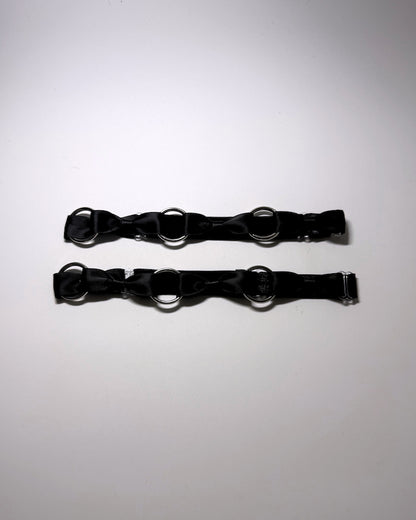 runaway black bow silver o ring leg garters on softly lit surface