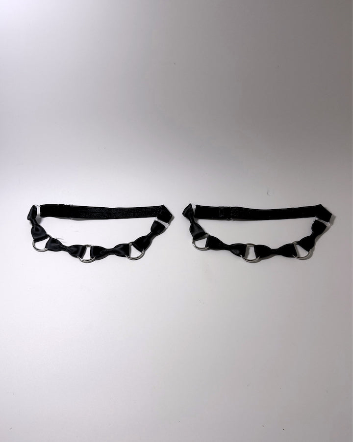 runaway black bow silver o ring leg garters on softly lit surface