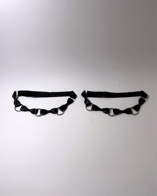 runaway black bow silver o ring leg garters on softly lit surface